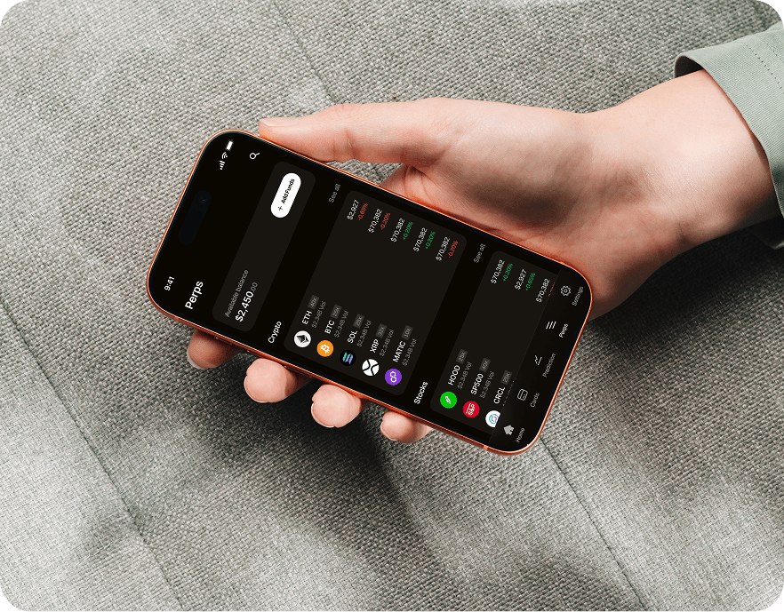 Photo — hand holding phone with the perps markets screen